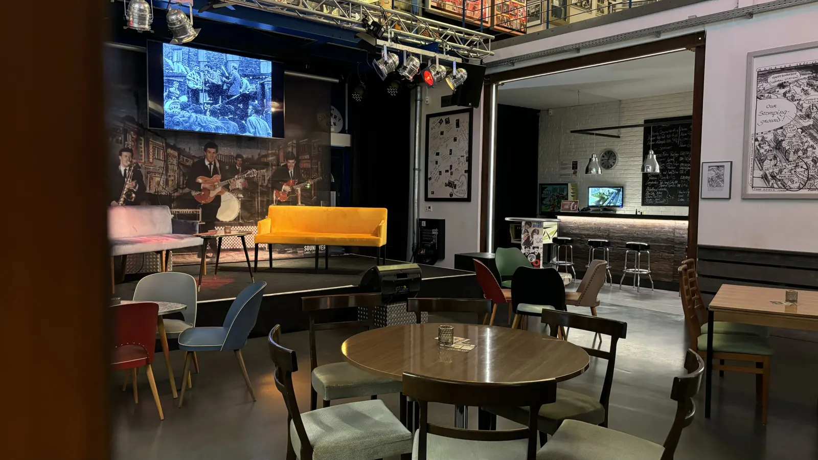 Soundwerk Eventcafé mit Vintage-Sitzgruppen, Bühne und Bar